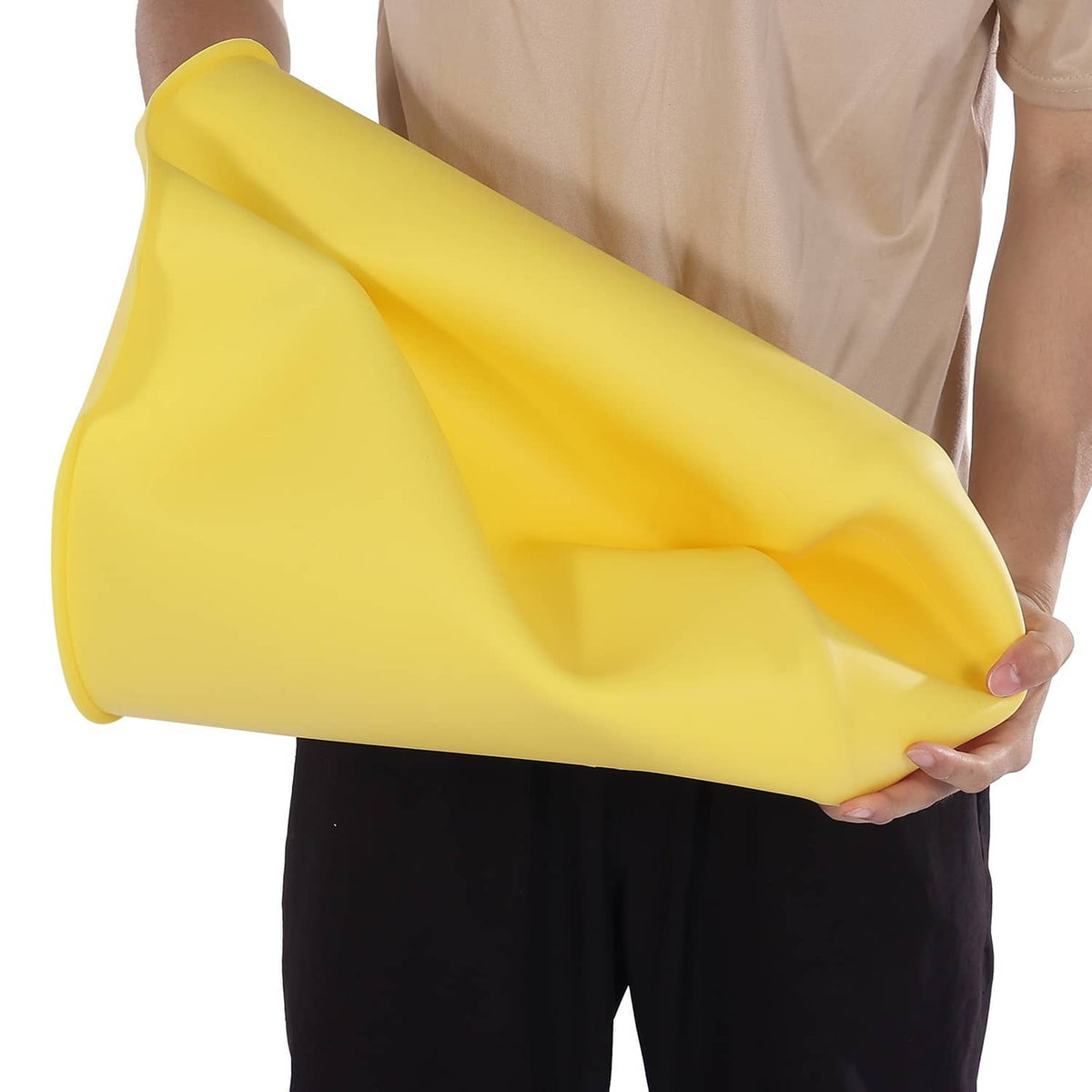 Yellow silicone bucket liner, rolled and held in hand