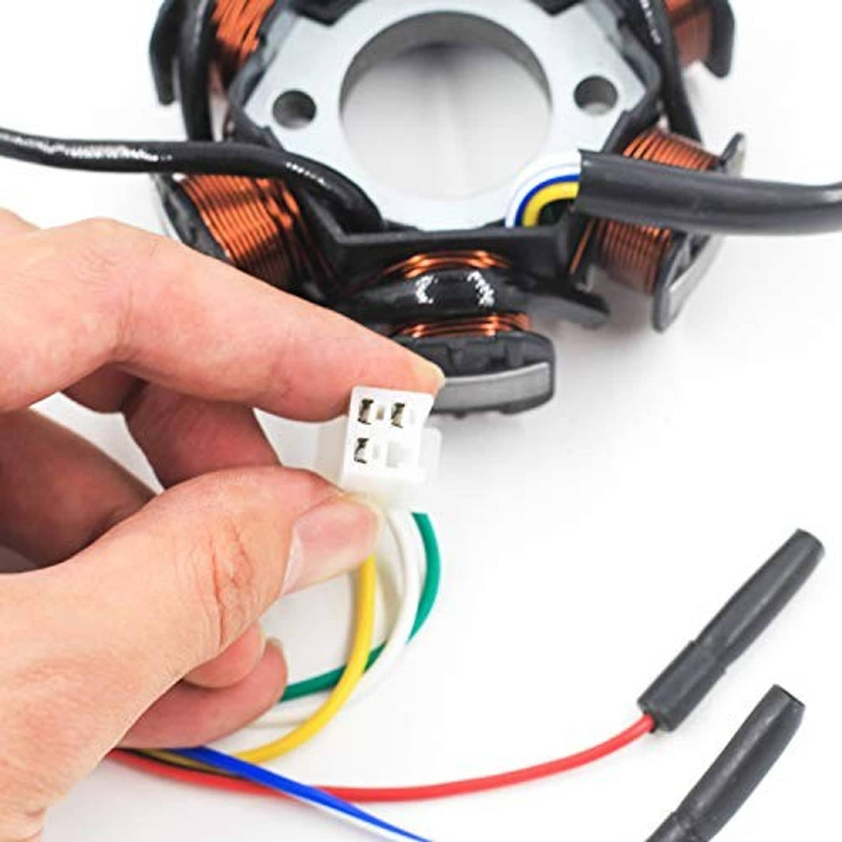 Ignition stator wire connector close-up with hand holding white multi-pin plug