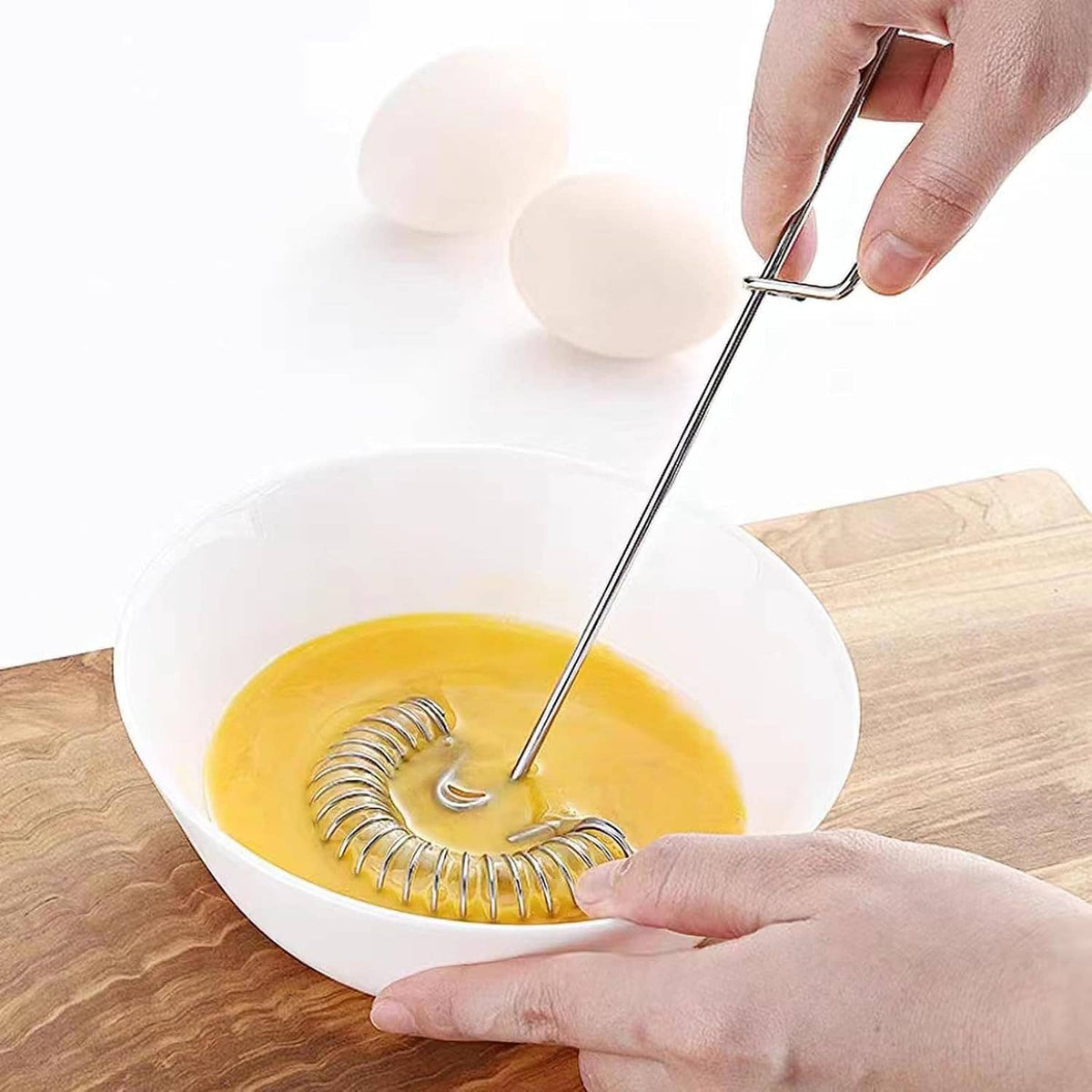 Stainless steel coil whisk stirring in a bowl of sauce or batter