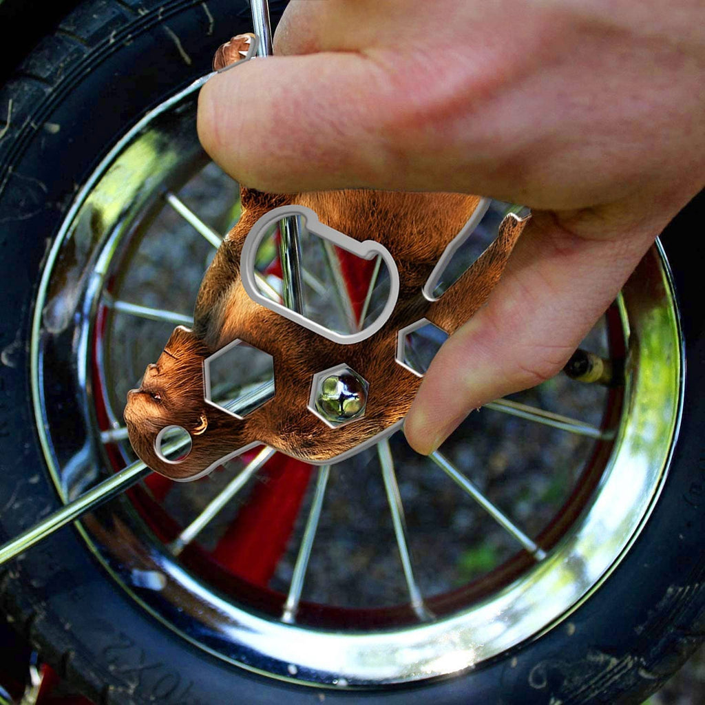 Sasquatch multi-tool used to pry and open a bottle cap on a wheel