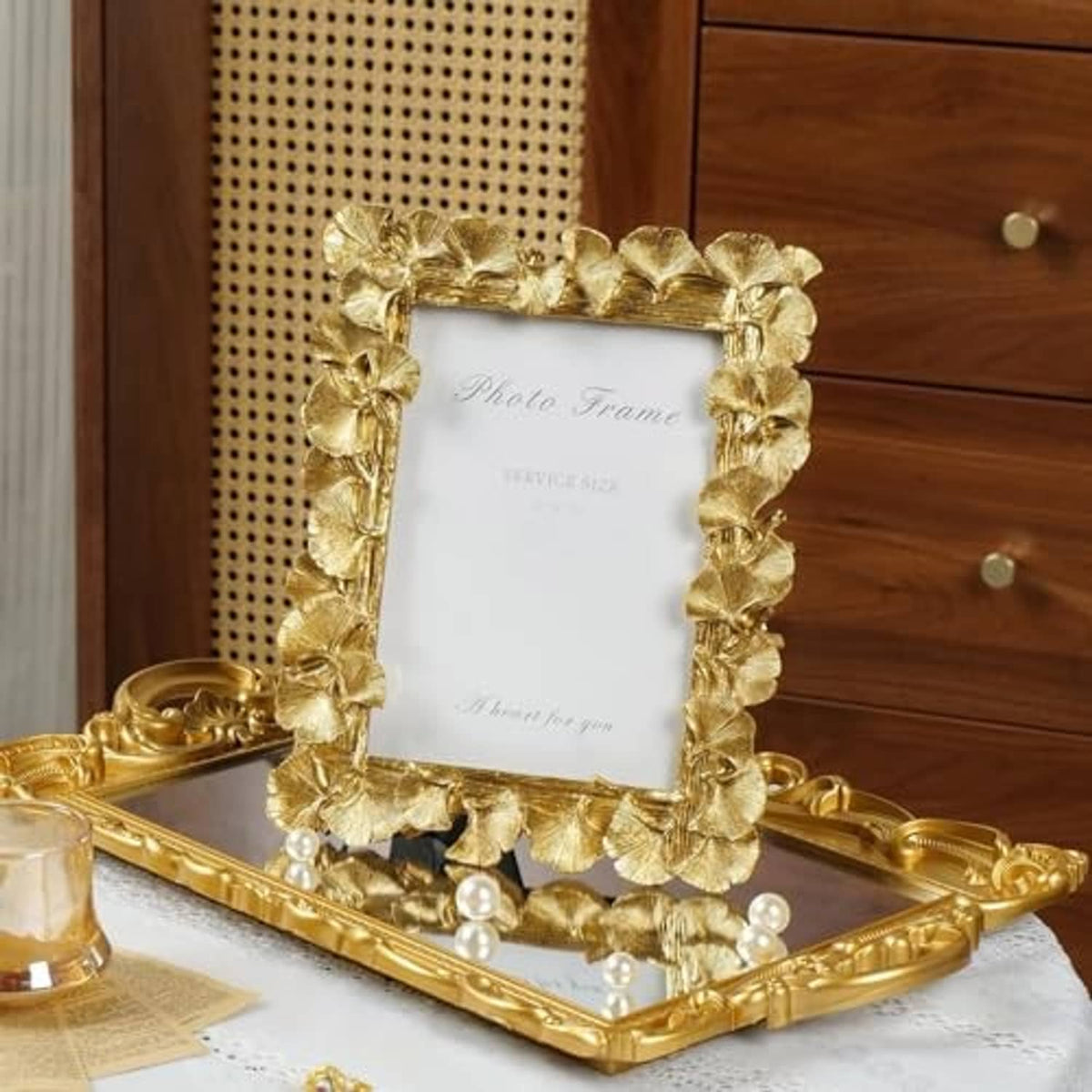 Gold ginkgo-leaf photo frame standing on tabletop, ornate leaf border