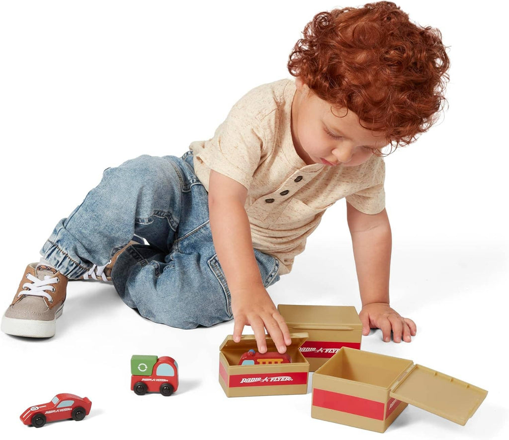 Red ride-on delivery truck toy with open cargo boxes; toddler reaching for pieces