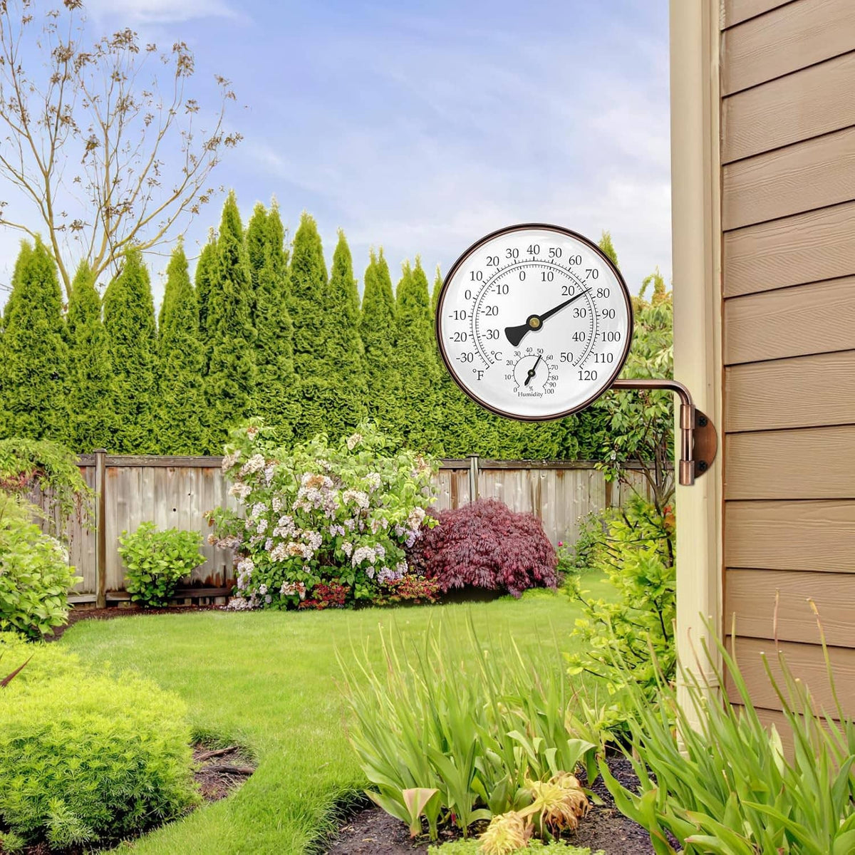 Brass swivel thermometer on an outdoor wall, round dial with C/F temperature and humidity