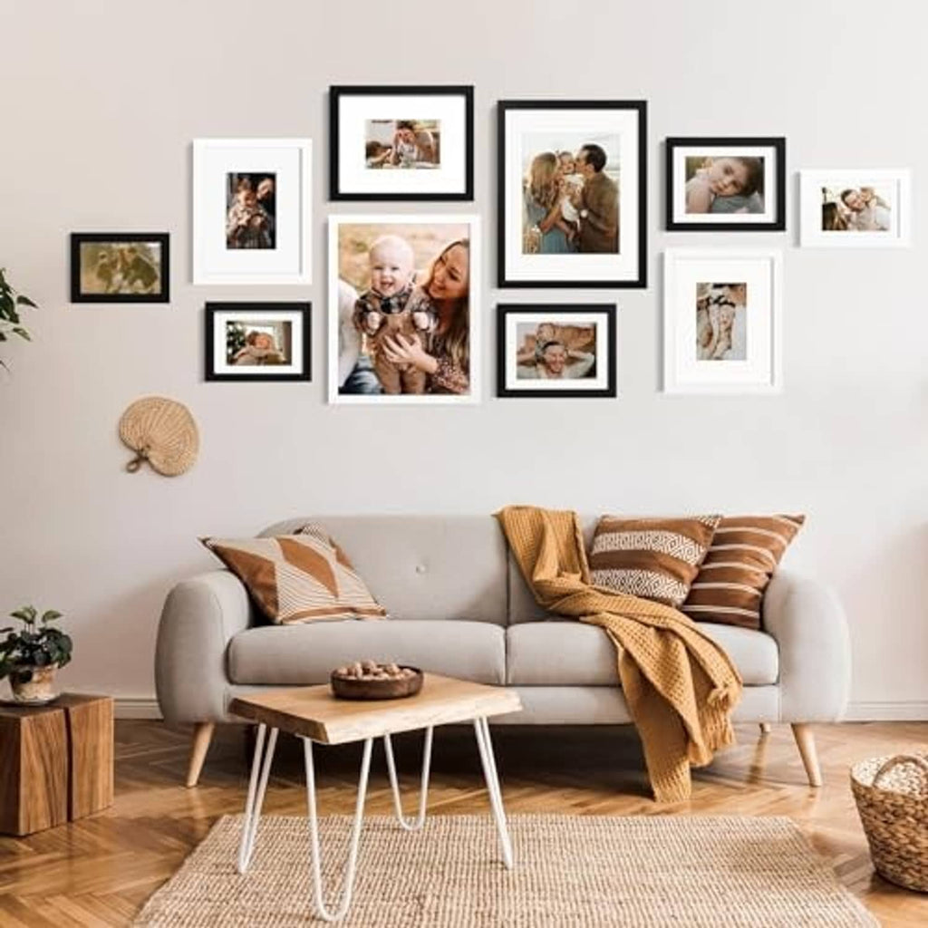 Black picture frame set arranged on wall with multiple photos in various sizes