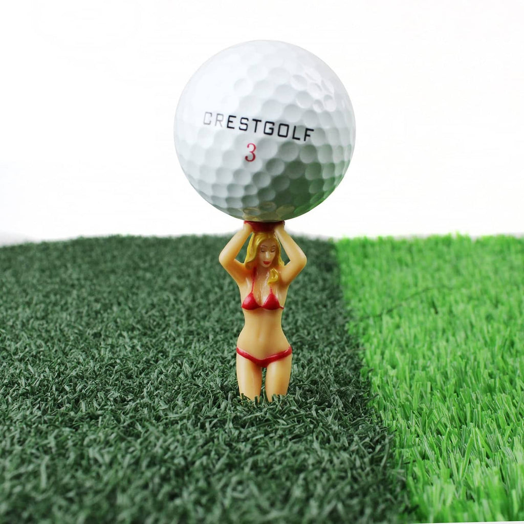 Golf tee with white ball head and red bikini figurine topper on grass