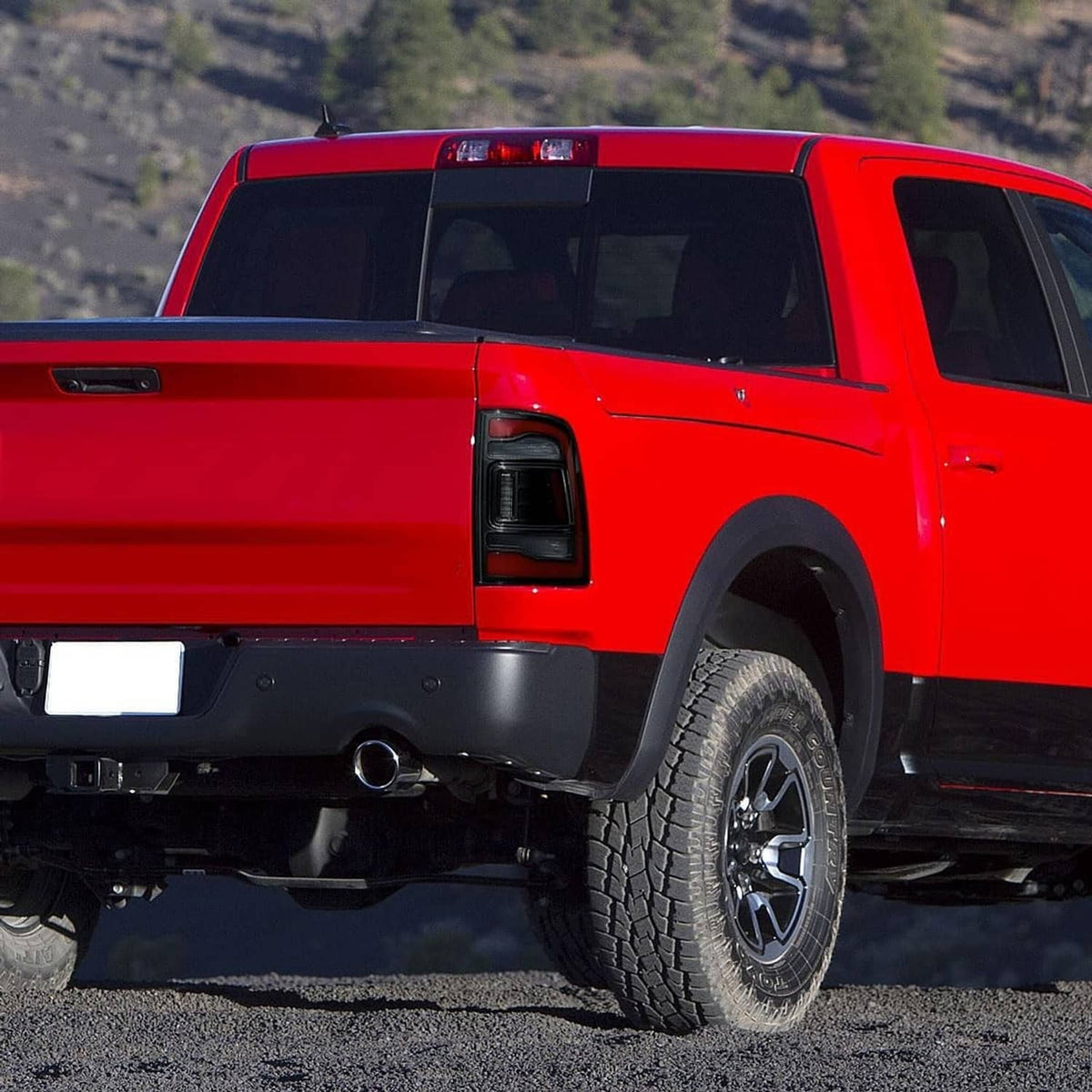 Rear truck LED tail light with red glow and dark housing on red pickup