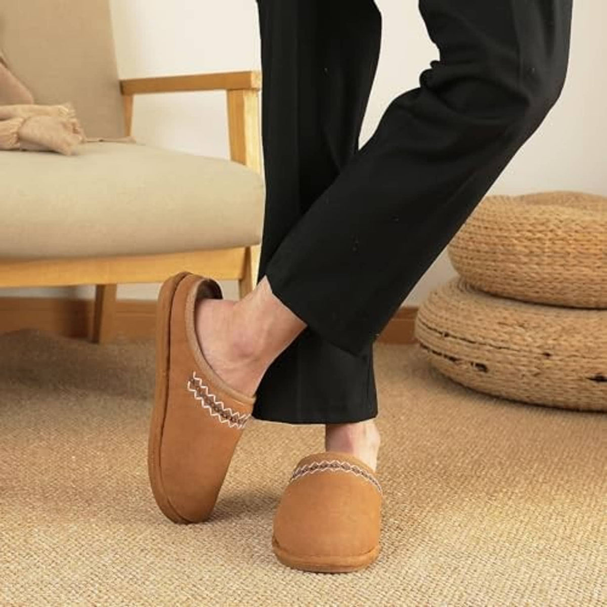 Chestnut suede slip-on slippers worn indoors with white trim and zigzag embroidery