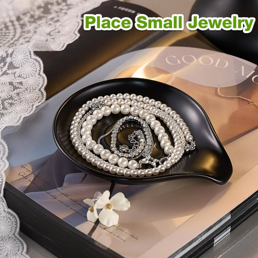 Black ceramic spoon rest used as a jewelry dish with pearl necklace on top