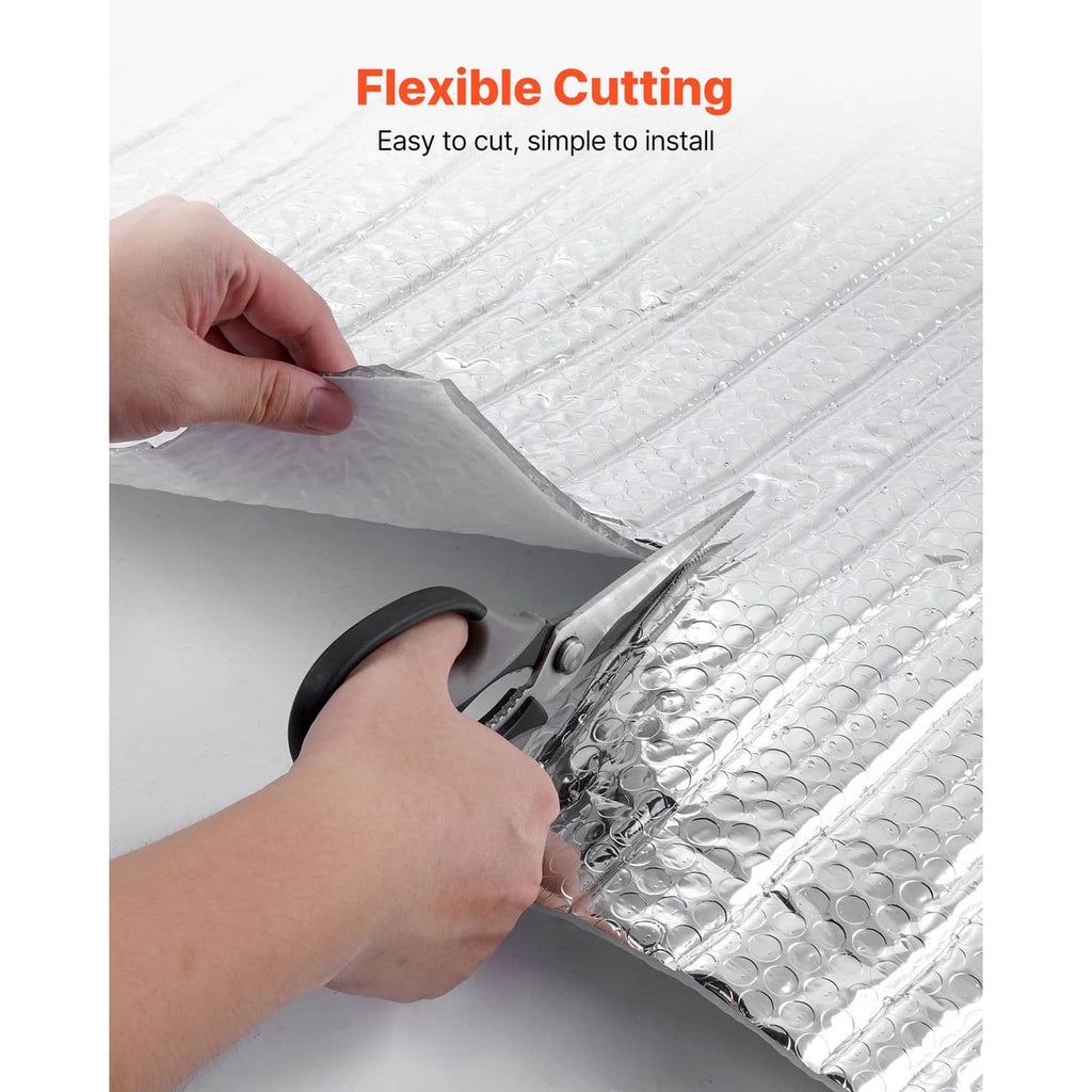 Reflective insulation panel being cut with scissors, showing foil and bubble film layers.
