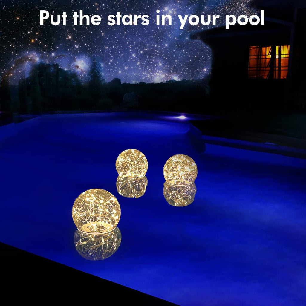 Warm-white glowing pool solar ball lights floating together in a dark pool