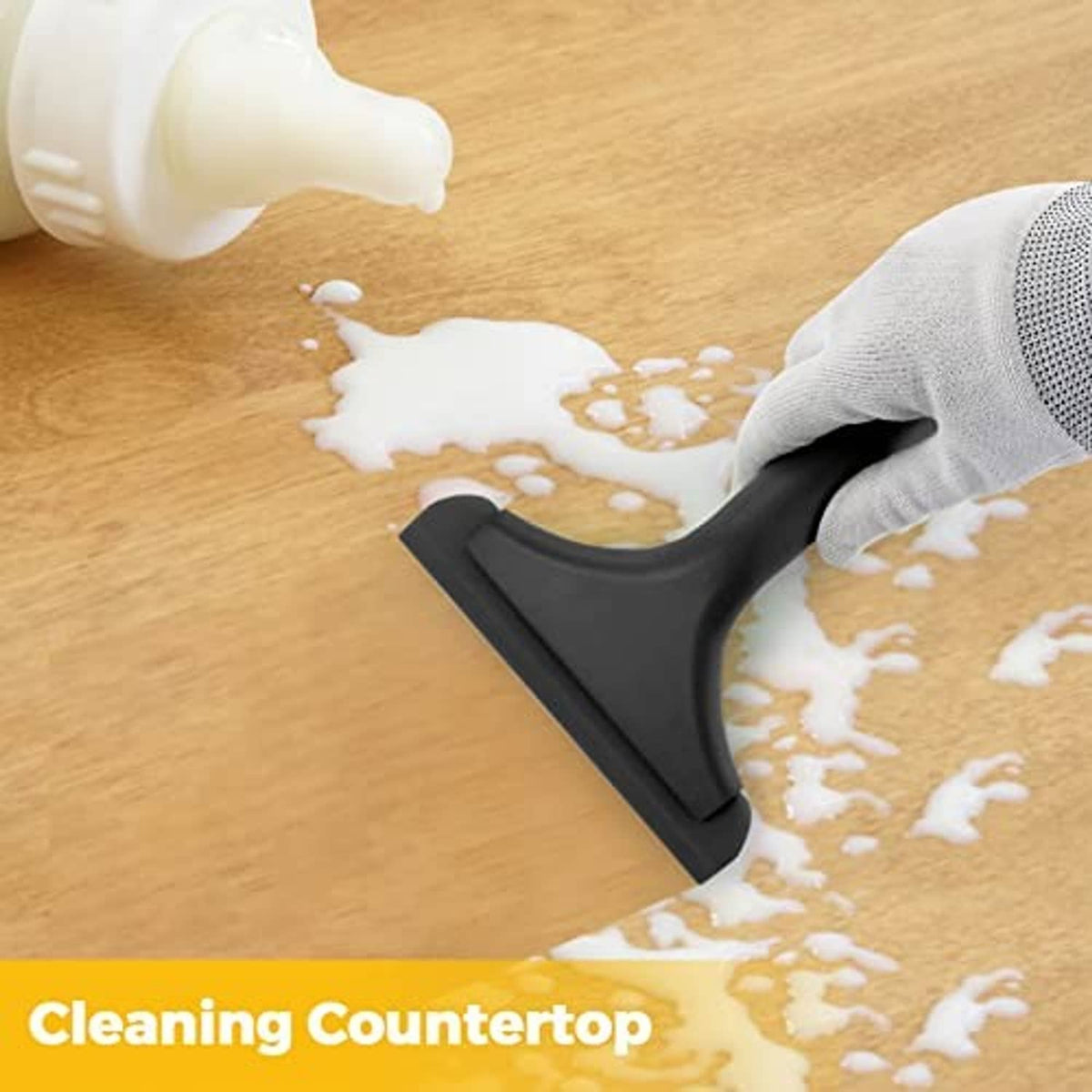 Black squeegee tool clearing soapy water from a countertop surface.