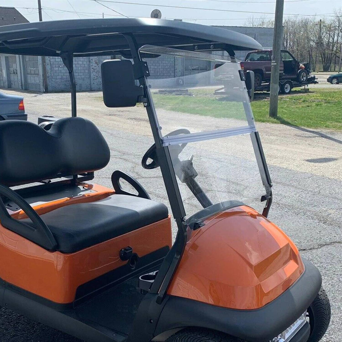 Clear foldable windshield on a golf cart with black frame