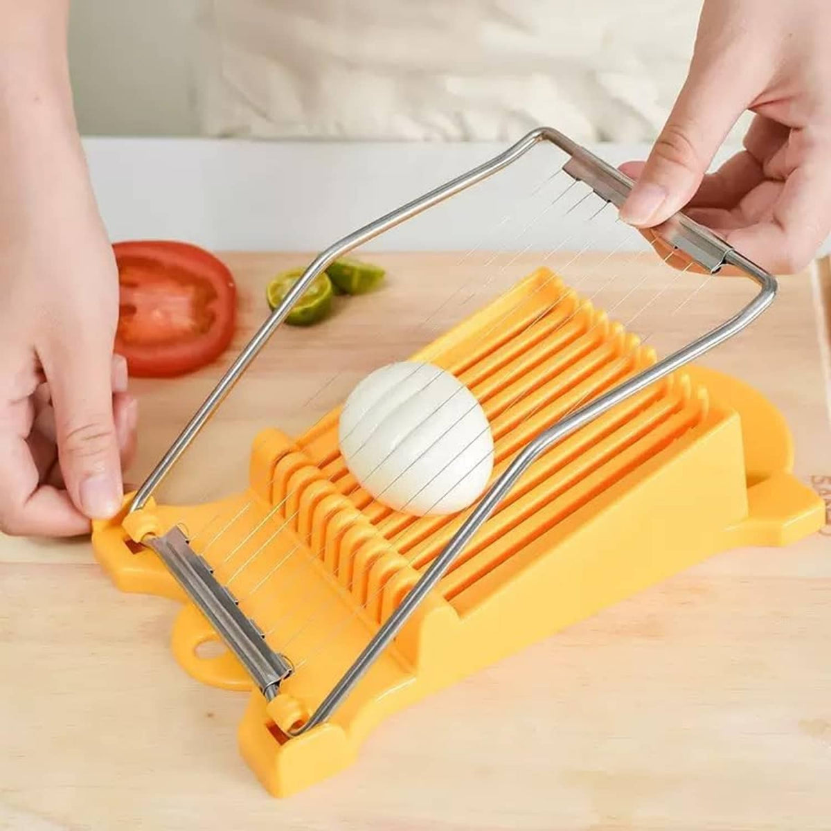 Yellow-and-silver slicer cutting vegetable slices on a countertop with hands
