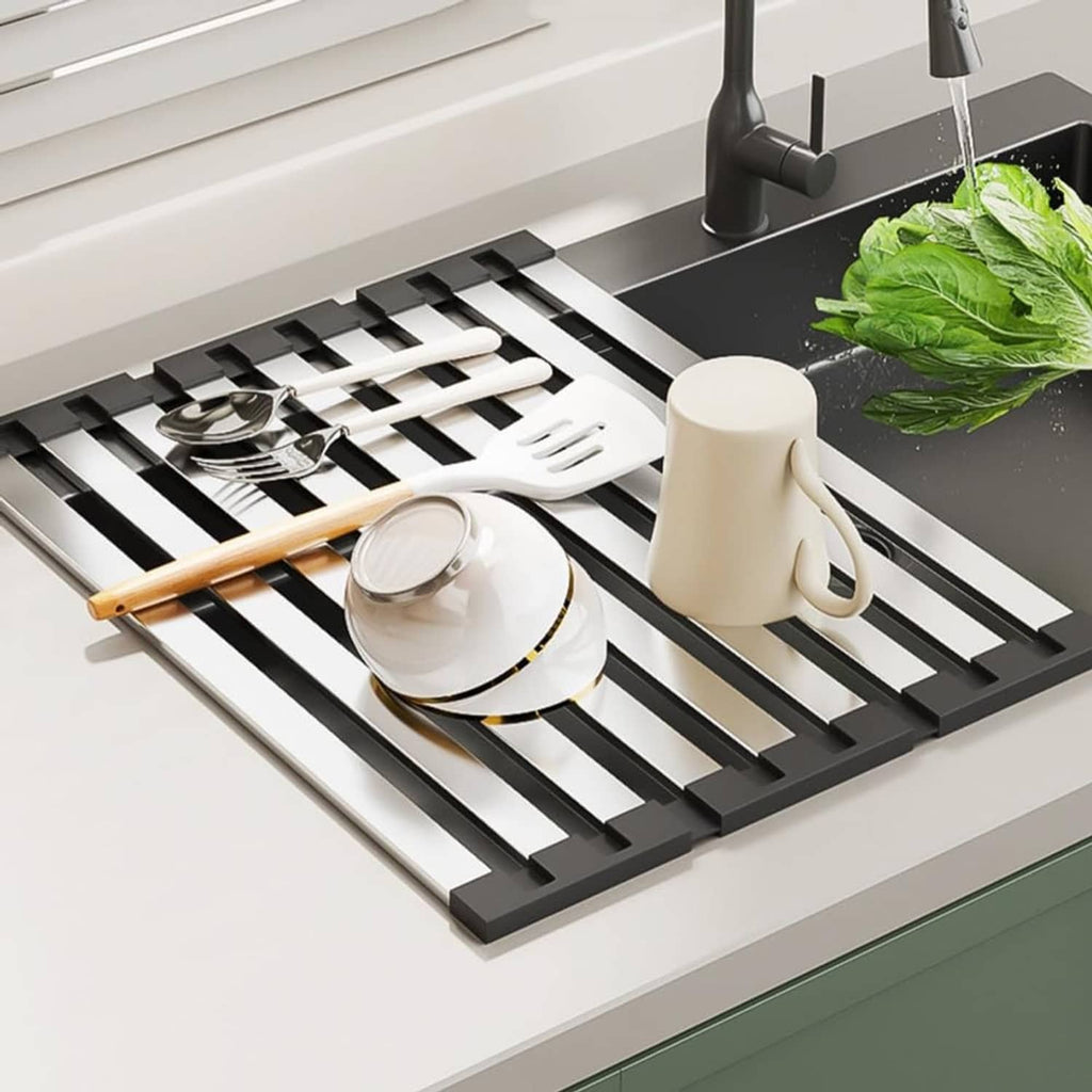 Dish drying rack in sink with plates, utensils, and greens on silver slats