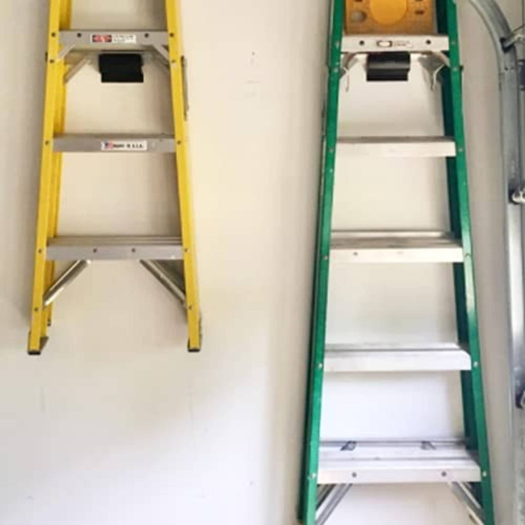 Ladder storage hooks mounted above two ladders in a garage