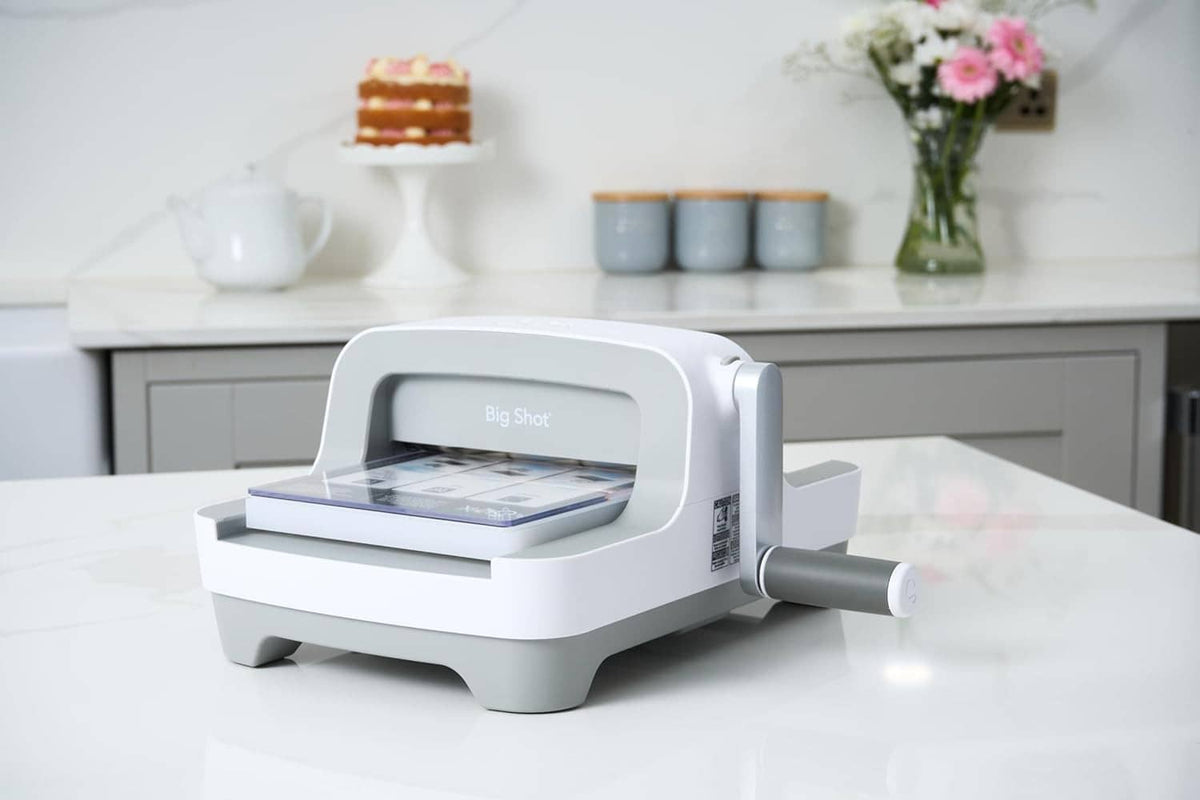 White Sizzix Big Shot die-cutting machine on tabletop, front open