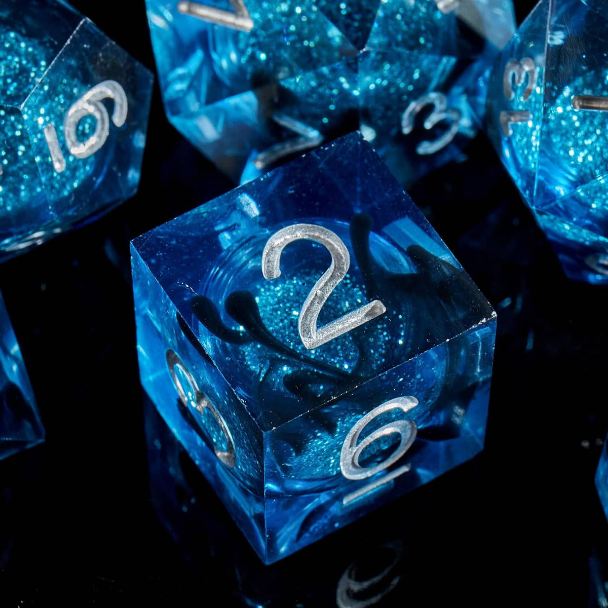 Close-up blue liquid-core D&D d2 with silver raised numbers and glitter
