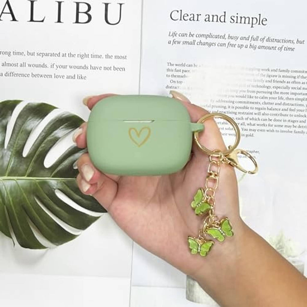 Hands holding matcha green silicone earbud case cover with butterfly charm key ring