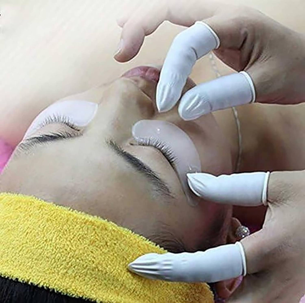 White latex finger cots on hands during use for hygiene and protection