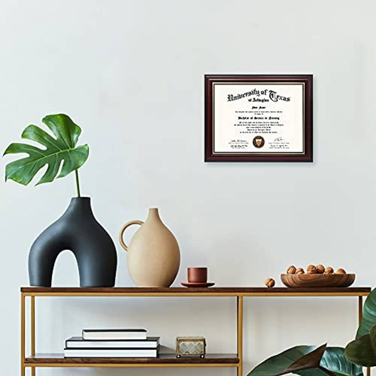 Small cherry wood certificate diploma frame with gold trim, hanging on a wall