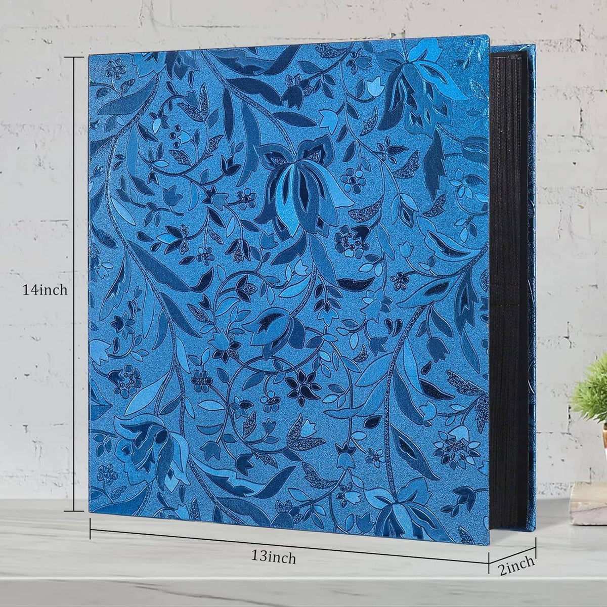 Blue floral photo album cover with dark spine, front view.