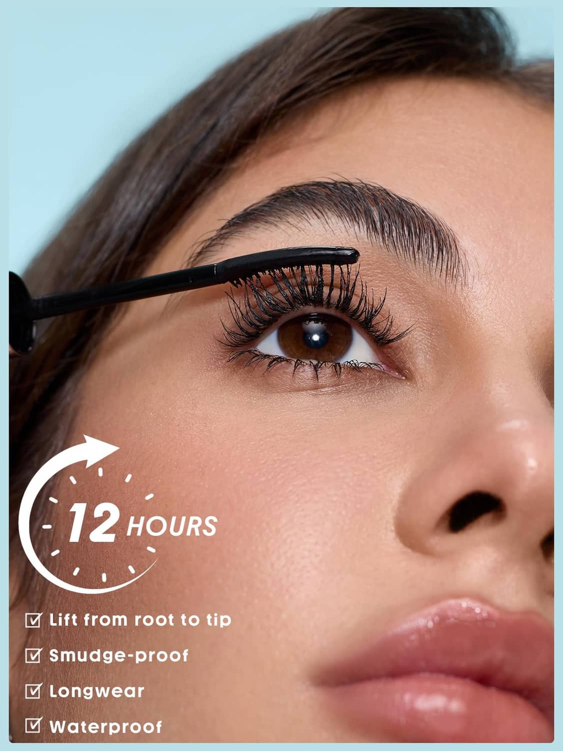 Black mascara brush applying to upper eyelashes