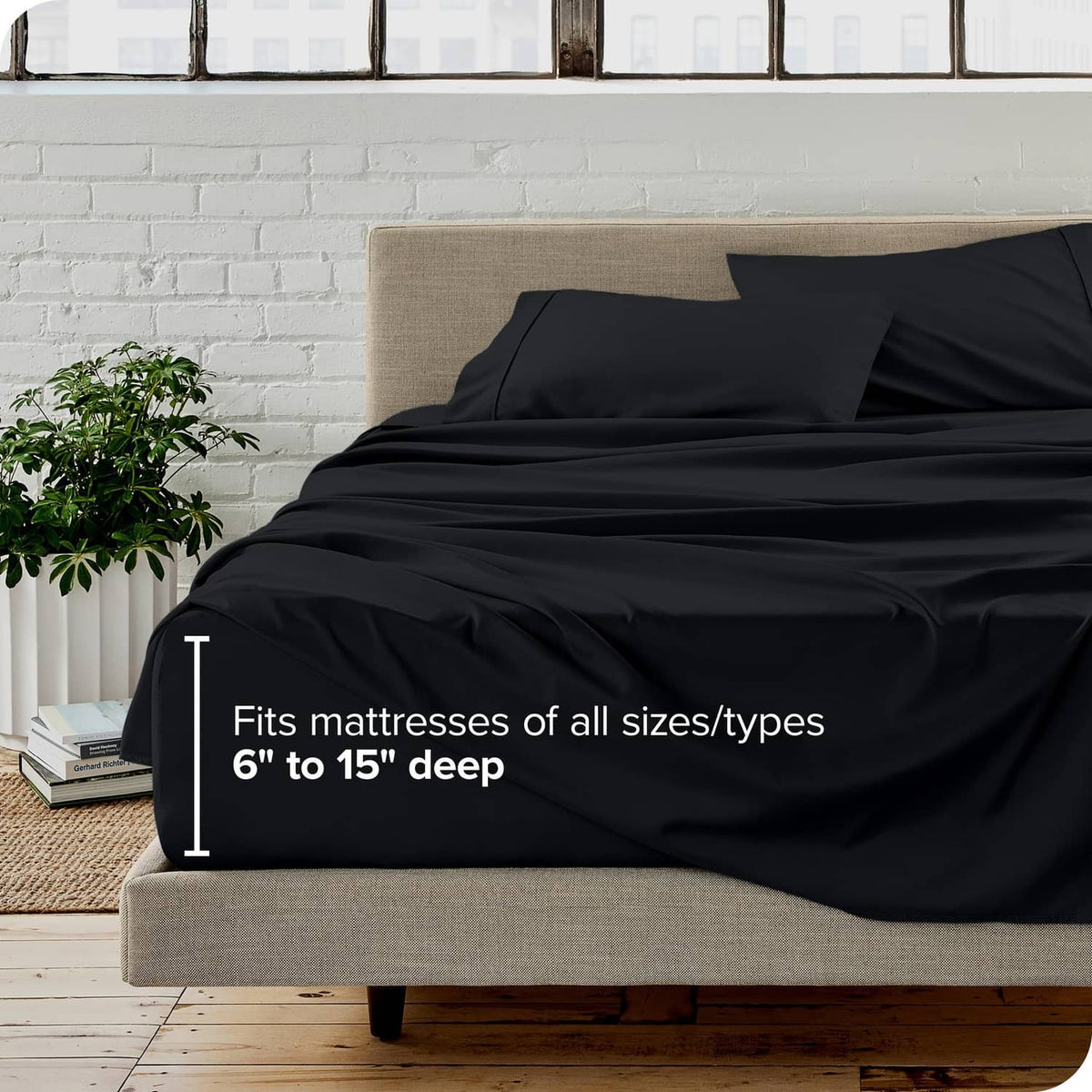 Black king fitted sheet draped over mattress with two matching pillow shams