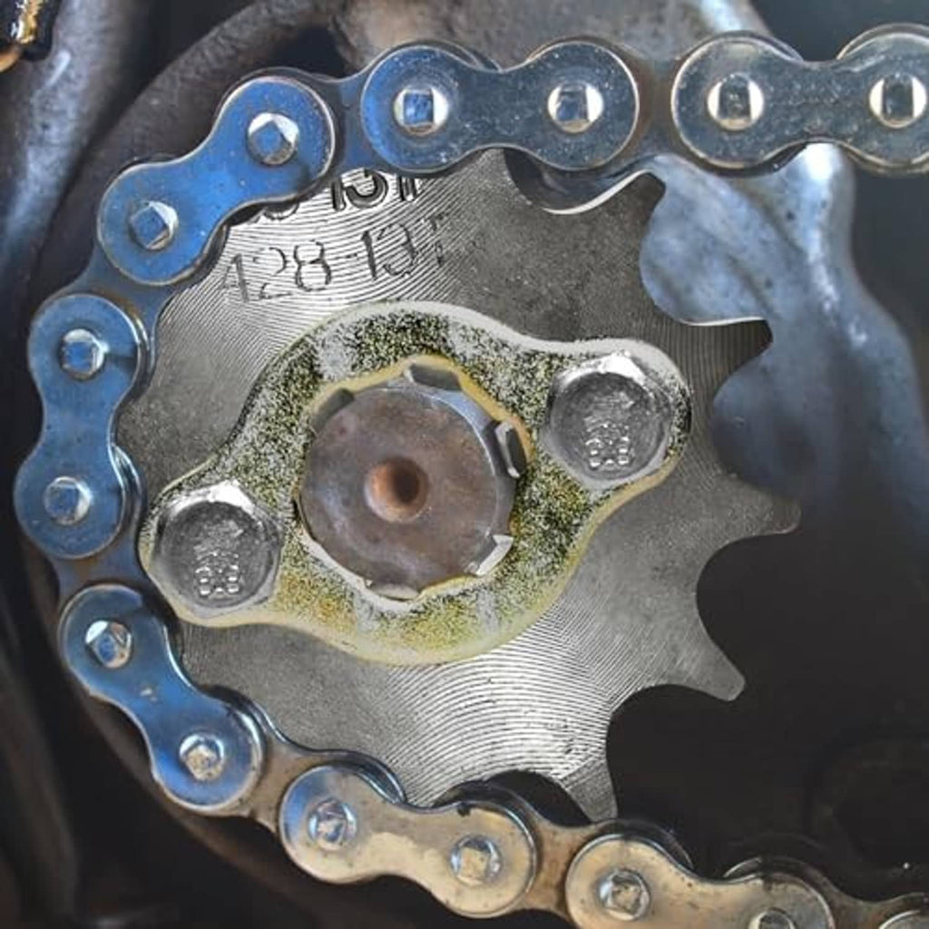 Front engine sprocket kit installed: chain with blue links and sprocket hub with residue