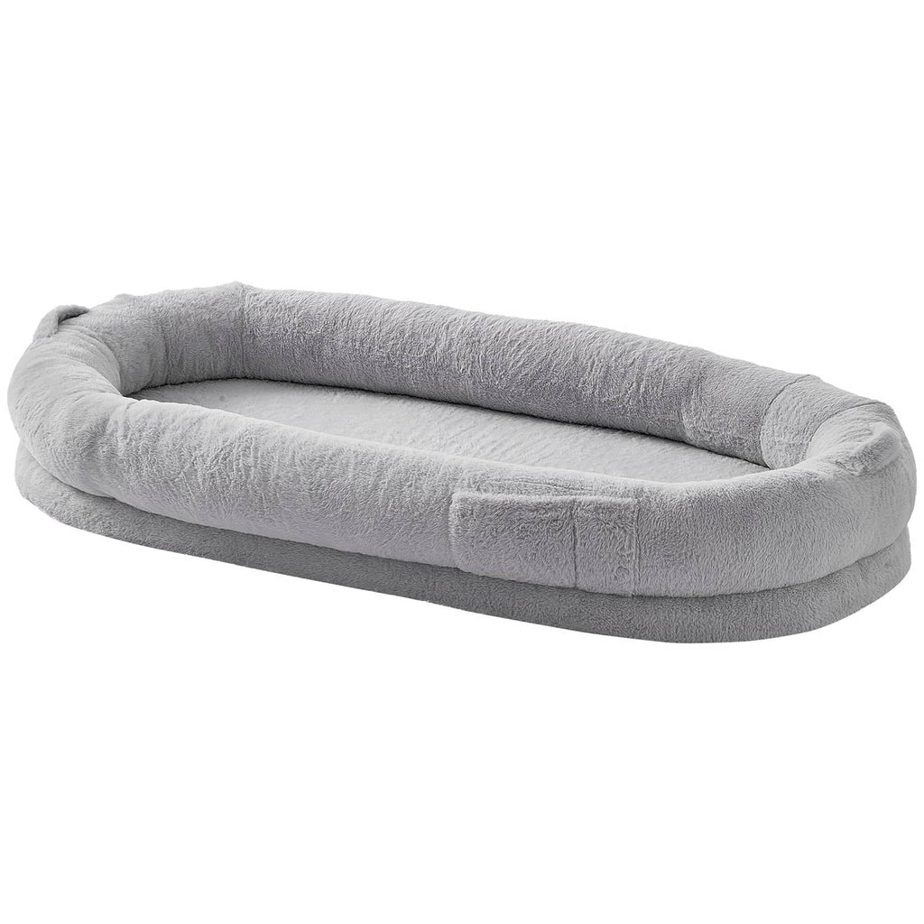 Grey oval dog bed with thick plush bolster and open center for pets to rest.