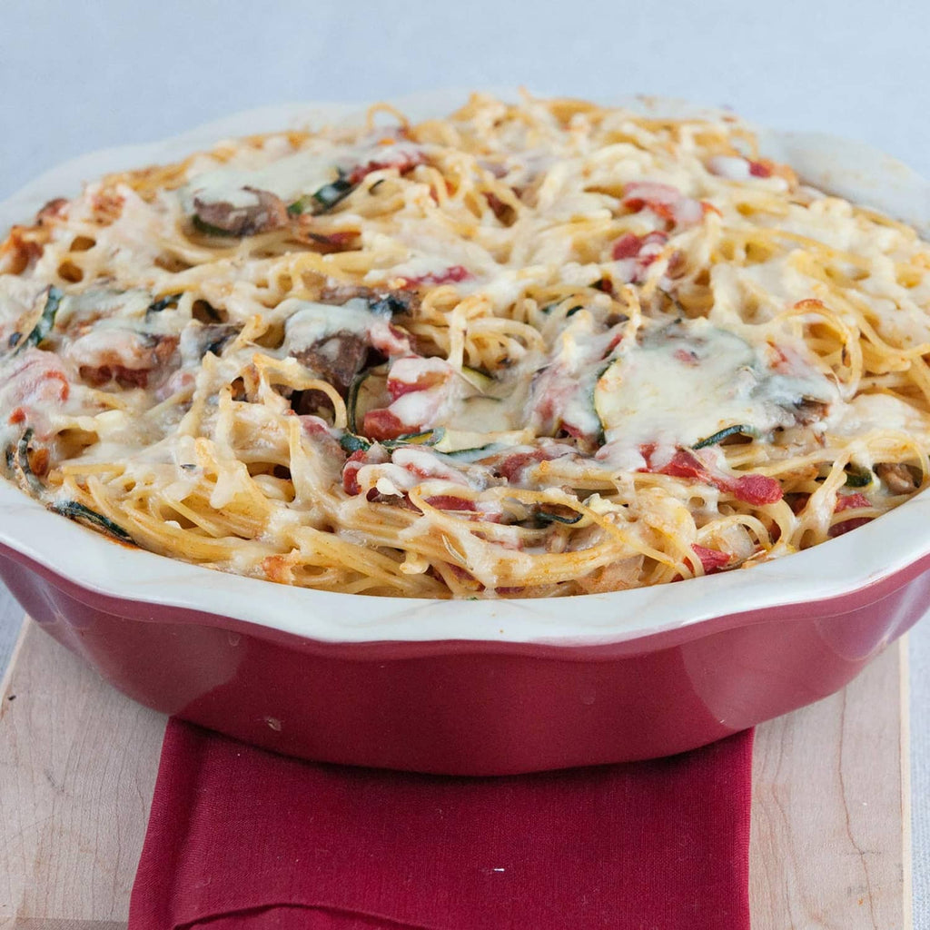 Baked spaghetti with cheese and herbs, mushroom sauce topped