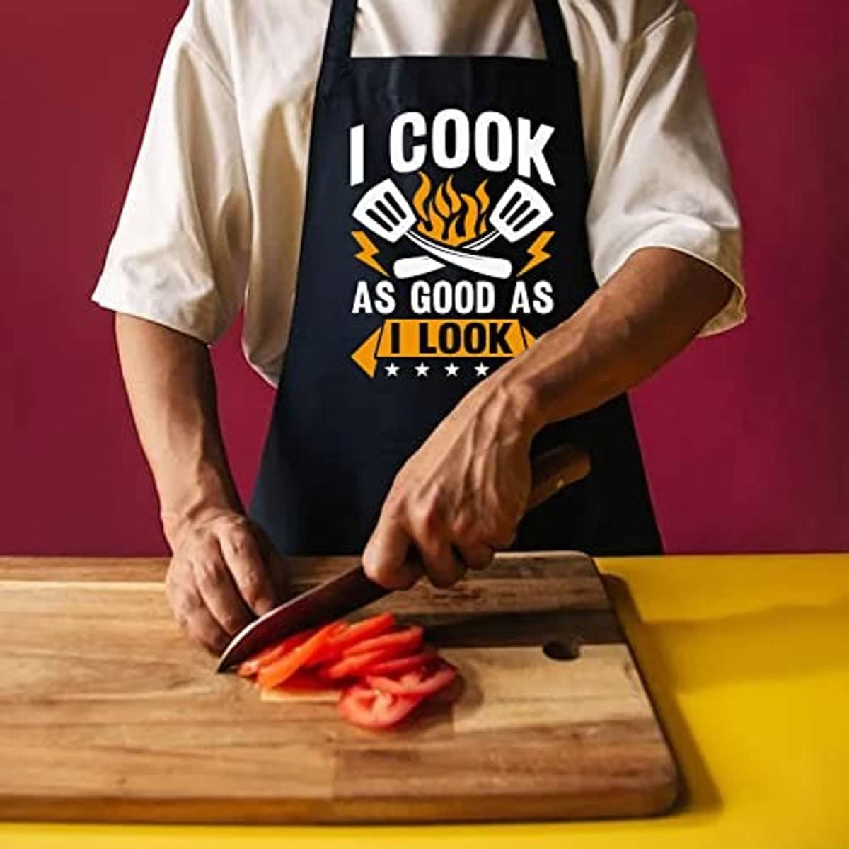 Black cooking apron on person, “I COOK AS GOOD AS I LOOK” graphic visible