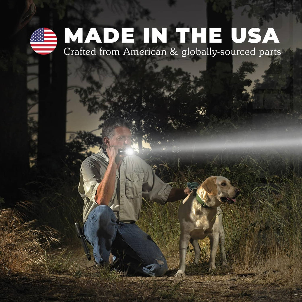 Silver flashlight shining a bright beam outdoors while held by a person