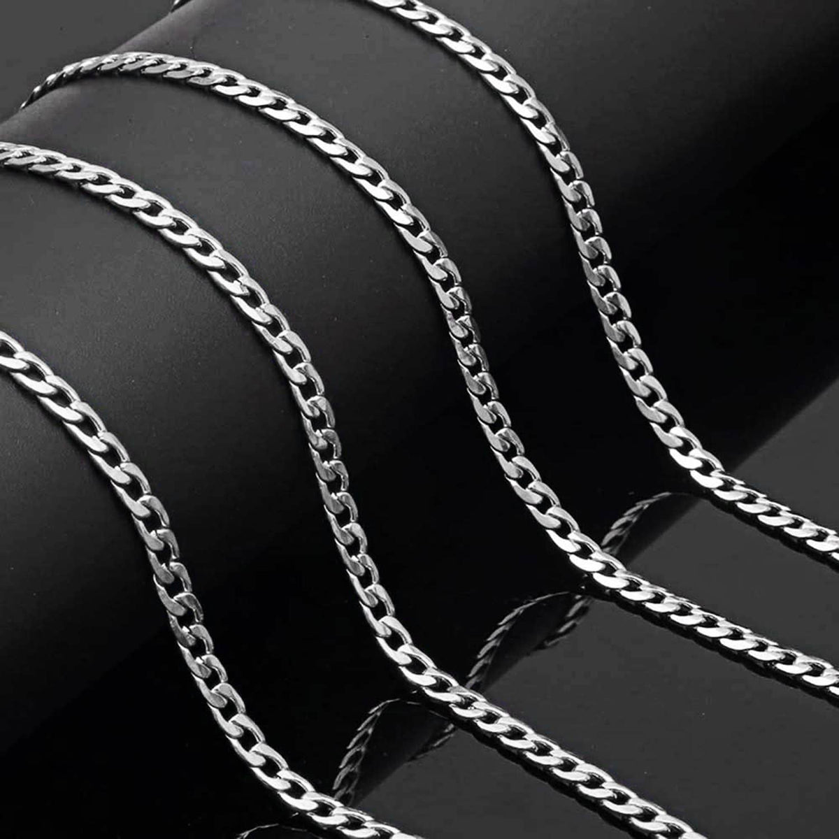 Silver Cuban link chain draped in curved rows with polished oval links