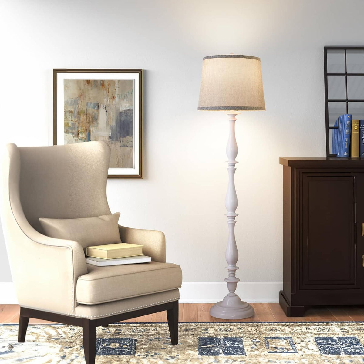Gray fabric drum lamp shade on a standing lamp with finial and socket ring