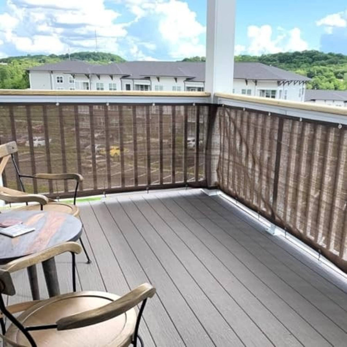Brown balcony privacy screen fabric panel on metal railing, corner grommet