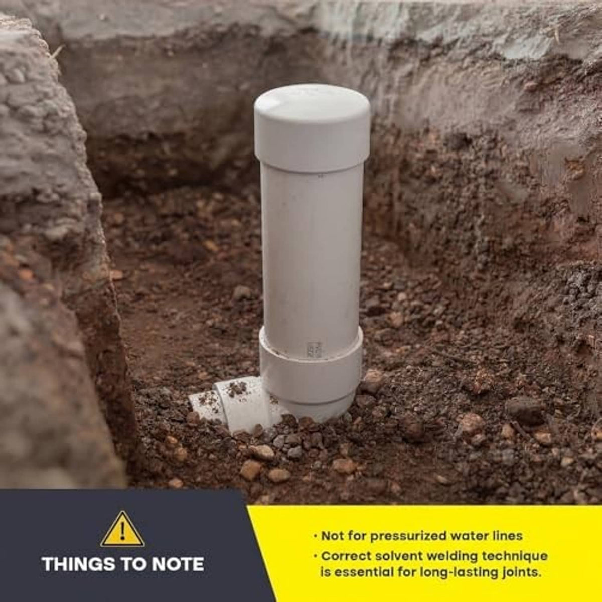 Installed white PVC DWV hub end cap upright on a drain pipe in ground