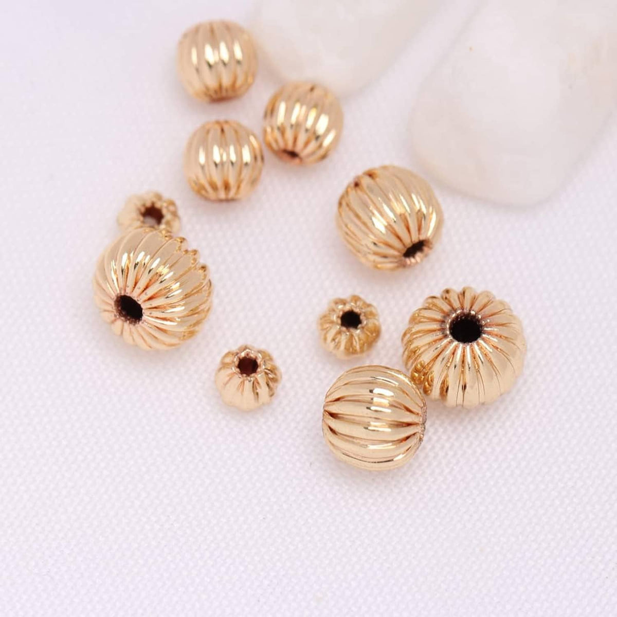 Gold-tone ribbed round beads with dark center holes, scattered set
