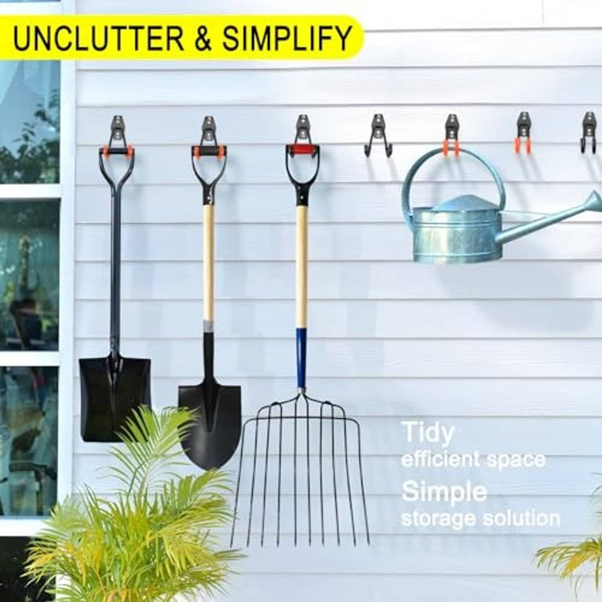Black wall hooks holding garden tools and watering can for tidy storage