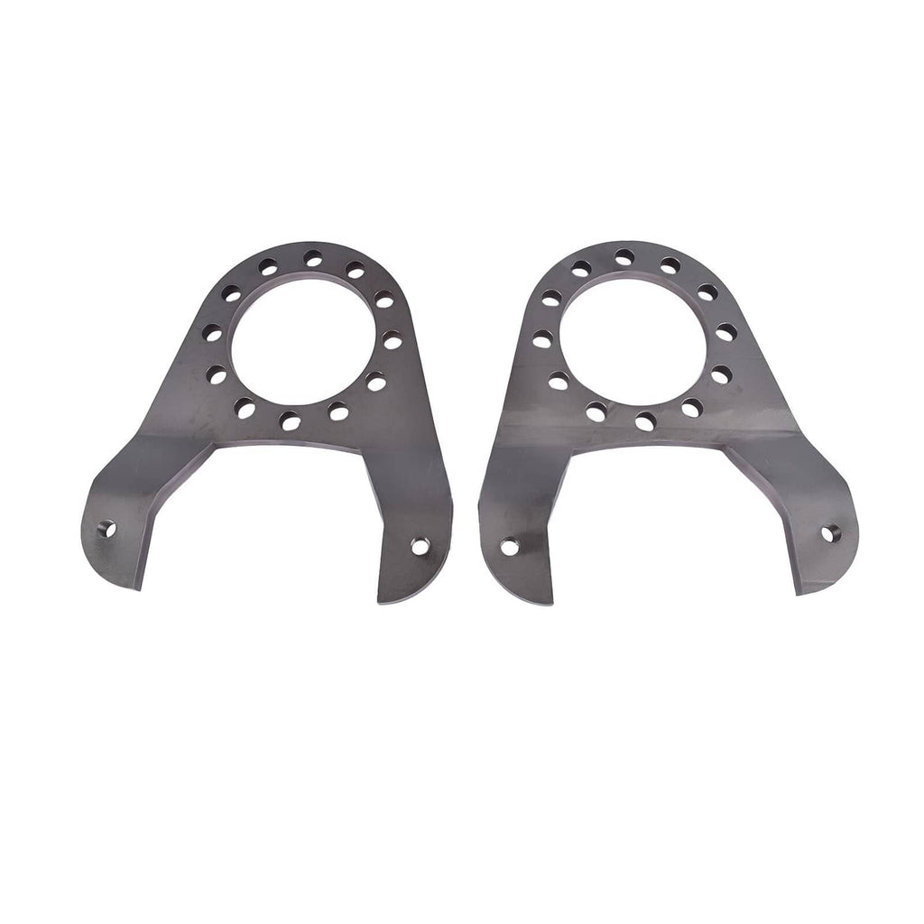 Two dark metal brake caliper brackets with circular mounting holes