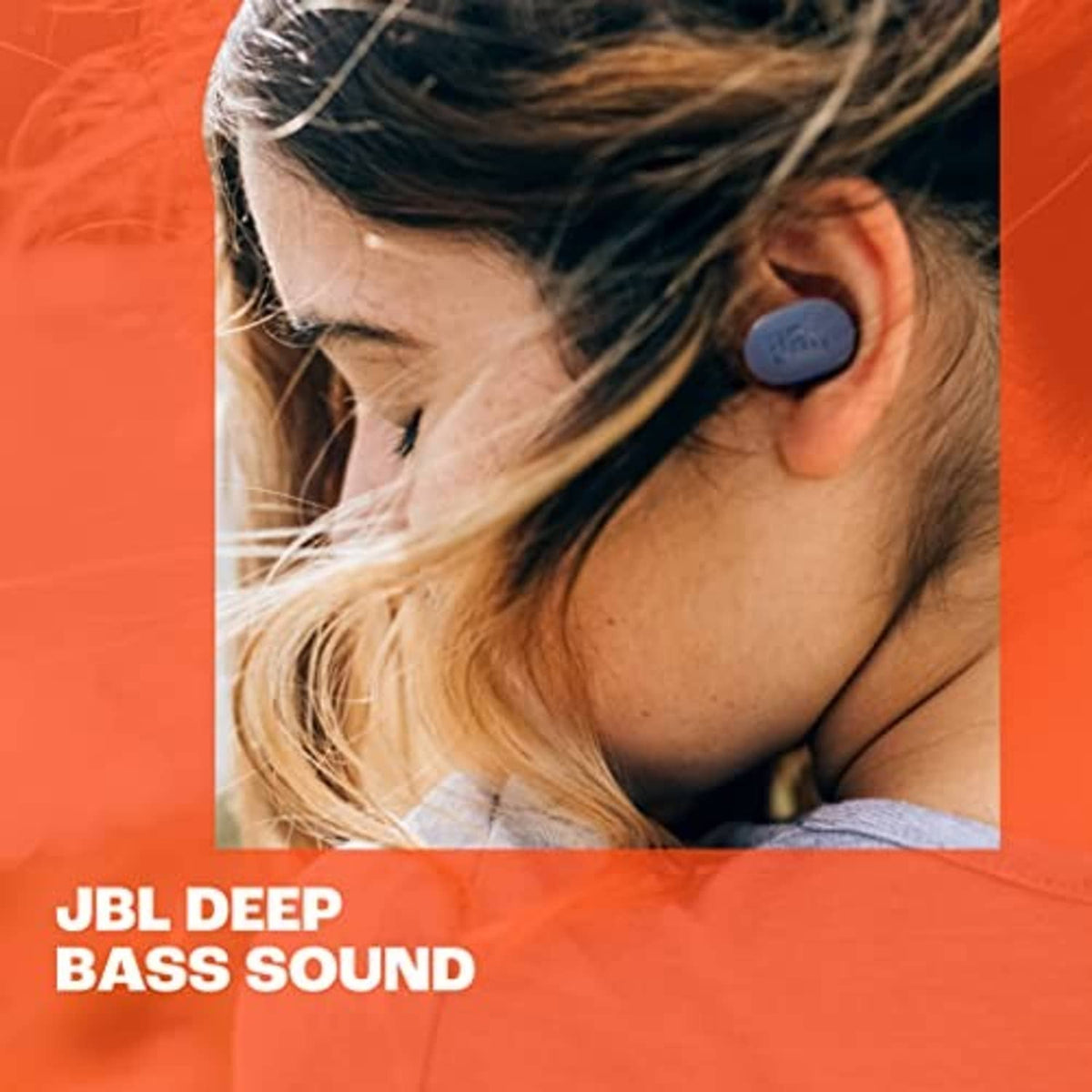Close-up of a woman wearing black JBL true wireless earbuds in her ear.