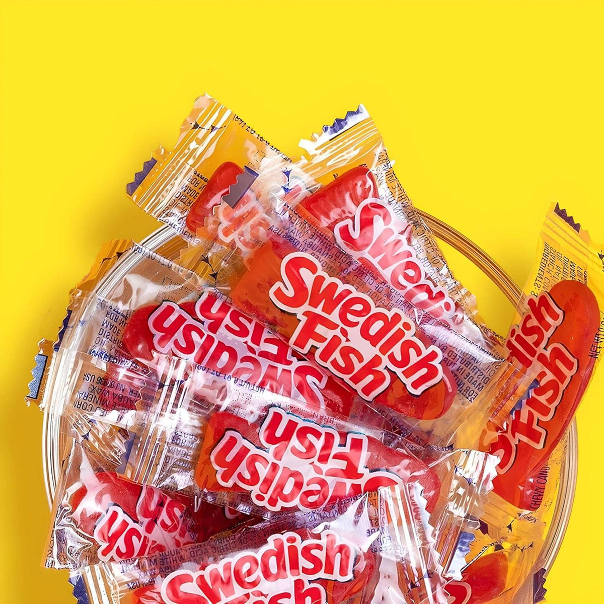 Individually wrapped Swedish Fish red gummies, layered assortment in wrappers
