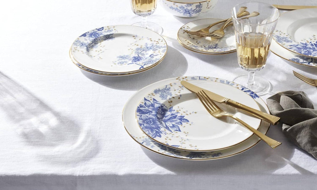 Blue floral porcelain plates with gold-rim cutlery on a table setting