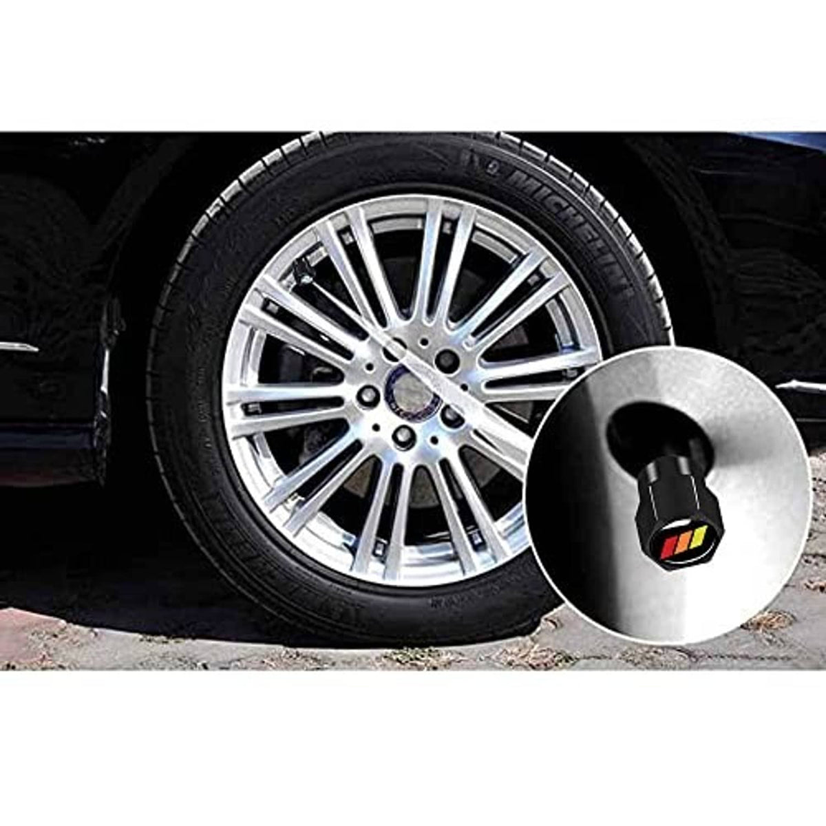 Black aluminum tire valve stem cap with tricolor emblem near chrome alloy wheel