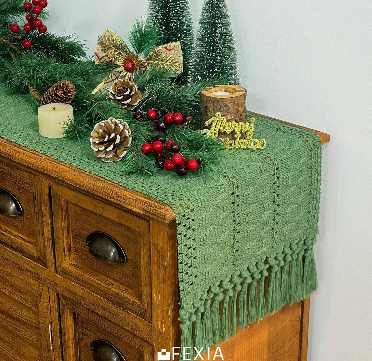 Green table runner with tassel fringe and textured weave, draped on console.