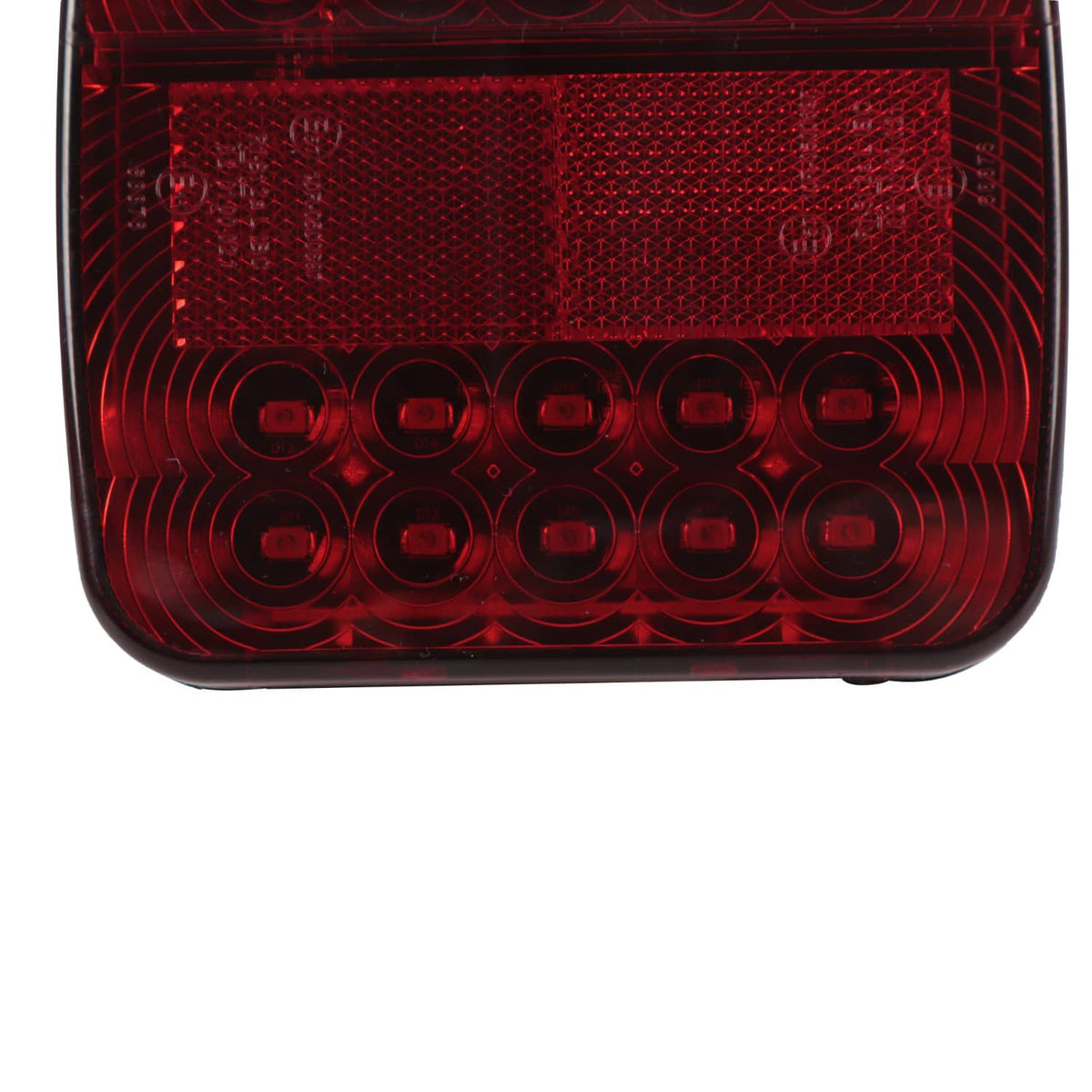 Red LED trailer light lens close-up showing inner rings and textured reflector