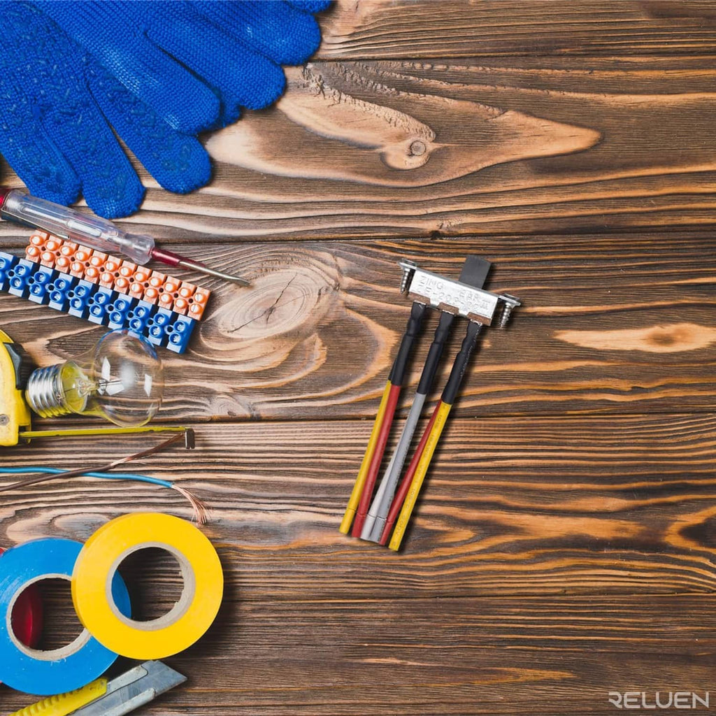 Wiring harness with slide switch connector and colored leads on wood surface with tape