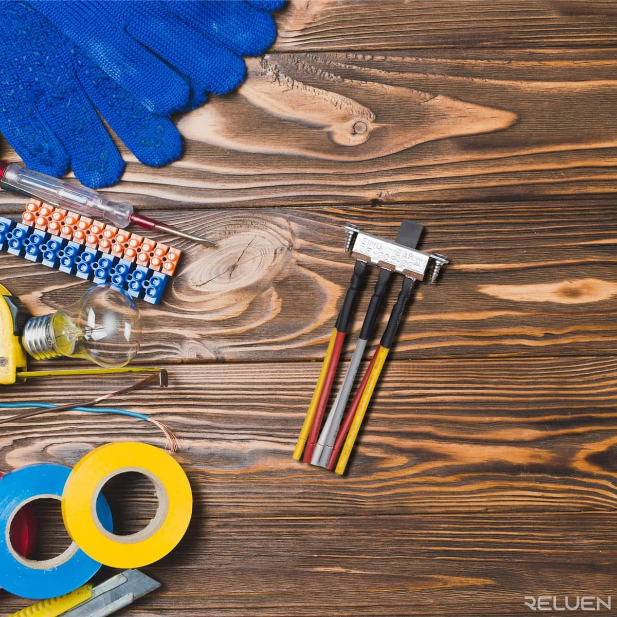 Wiring harness with slide switch connector and colored leads on wood surface with tape