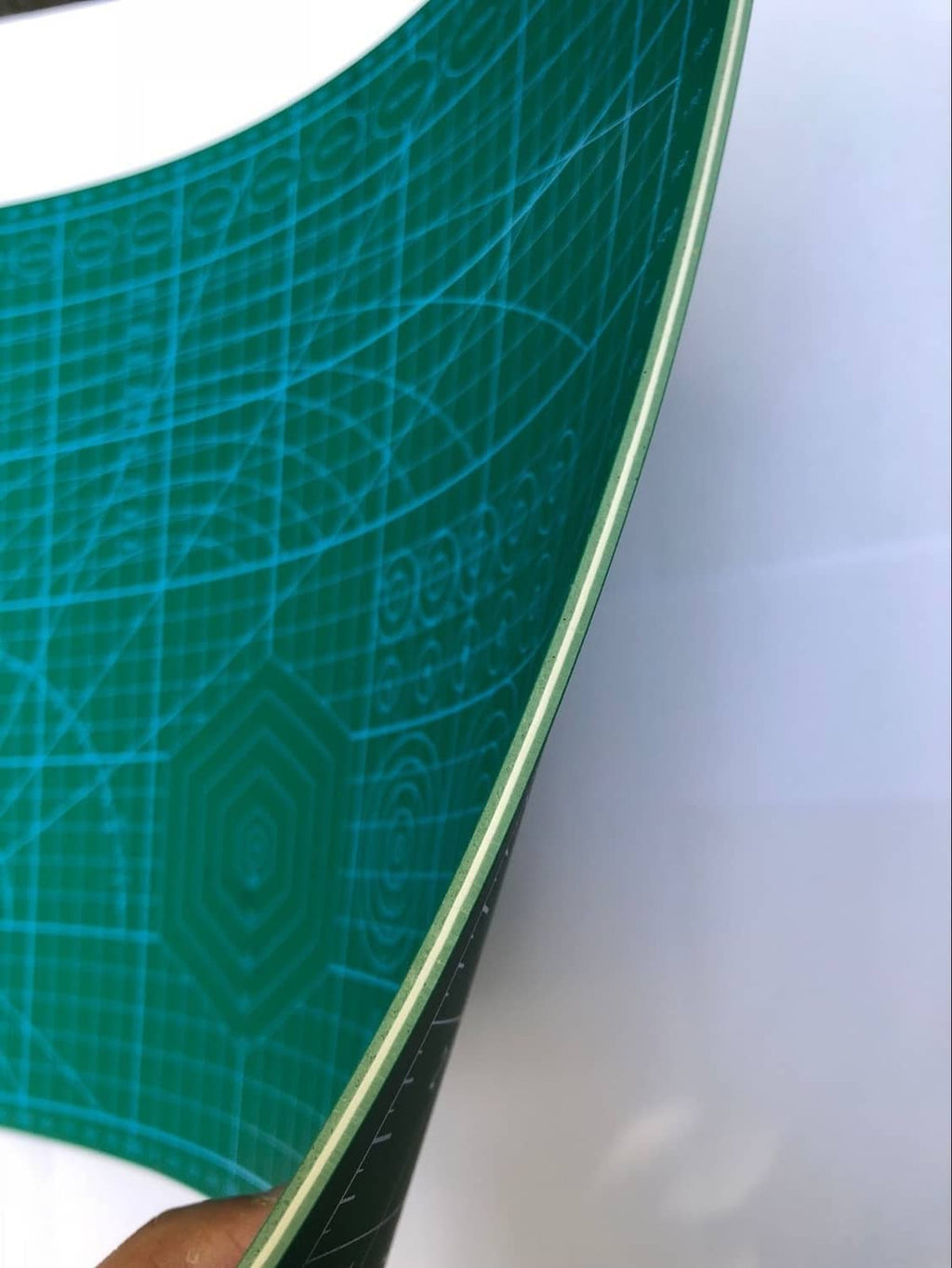 Corner of blue cutting mat with thick border and printed measurement lines