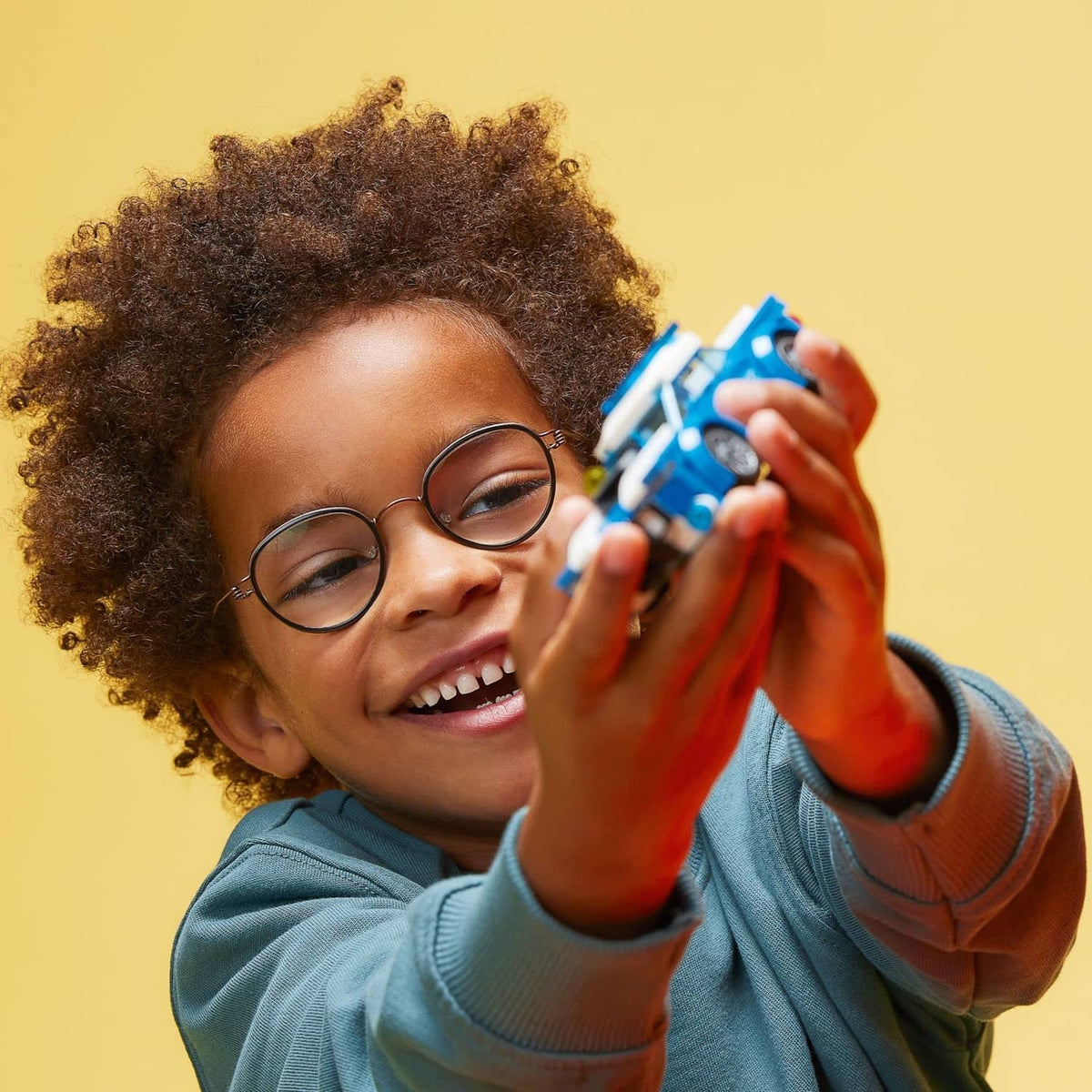 Kid holding a blue police toy car