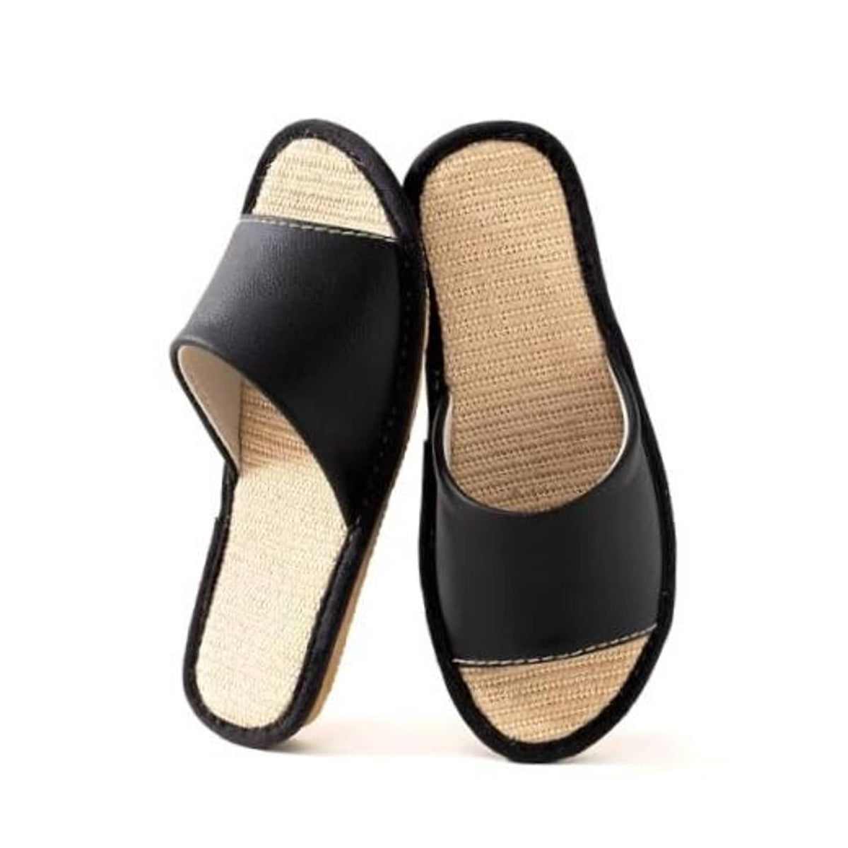 Black leather house slippers with beige woven insoles, open-back slip-on design.